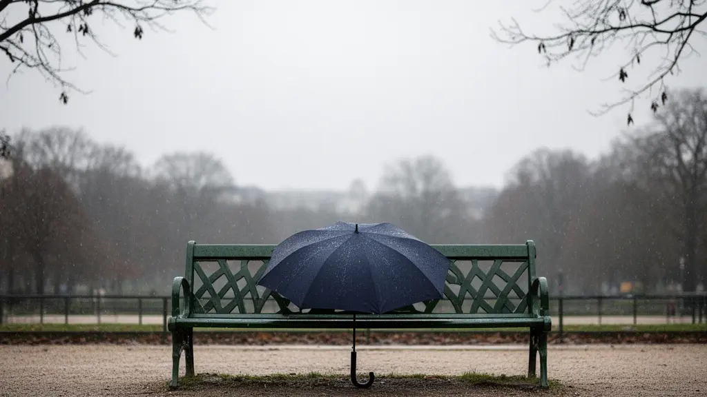 Vue large et minimaliste d'un parapluie ouvert posé sur un banc de jardin parisien sous une pluie légère, symbolisant la protection insuffisante de la Sécurité sociale