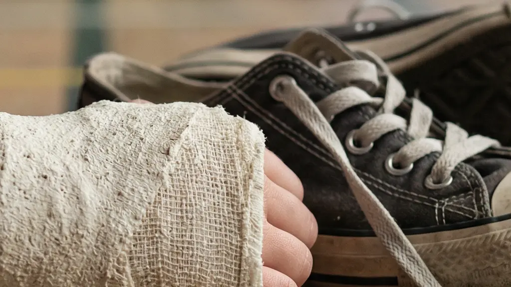 Gros plan sur la texture d'un plâtre d'enfant et une paire de lacets défaits sur un sol d'école, évoquant une chute sans témoin.